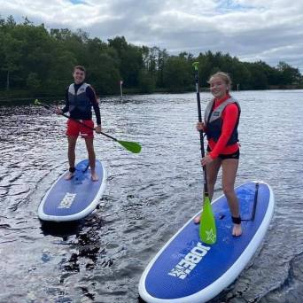 a group of people standing next to a body of water