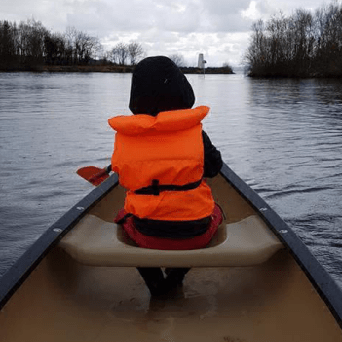 a person sitting in a boat on a body of water