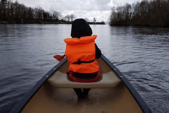 a person sitting in a boat on a body of water