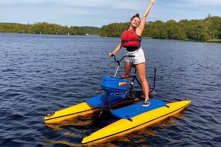 a man riding on the back of a boat in a body of water