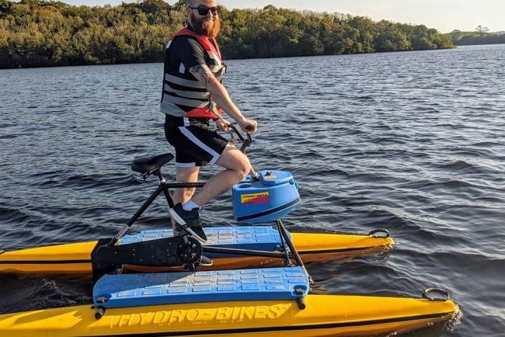 a man riding on the back of a boat in a body of water