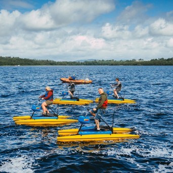 a group of people riding on the back of a boat in the water