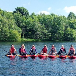 a group of people riding on the back of a boat in the water