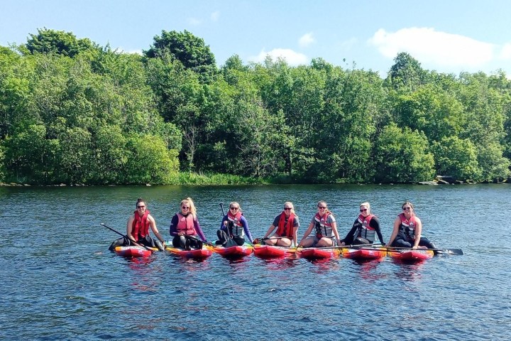 a group of people riding on the back of a boat in the water